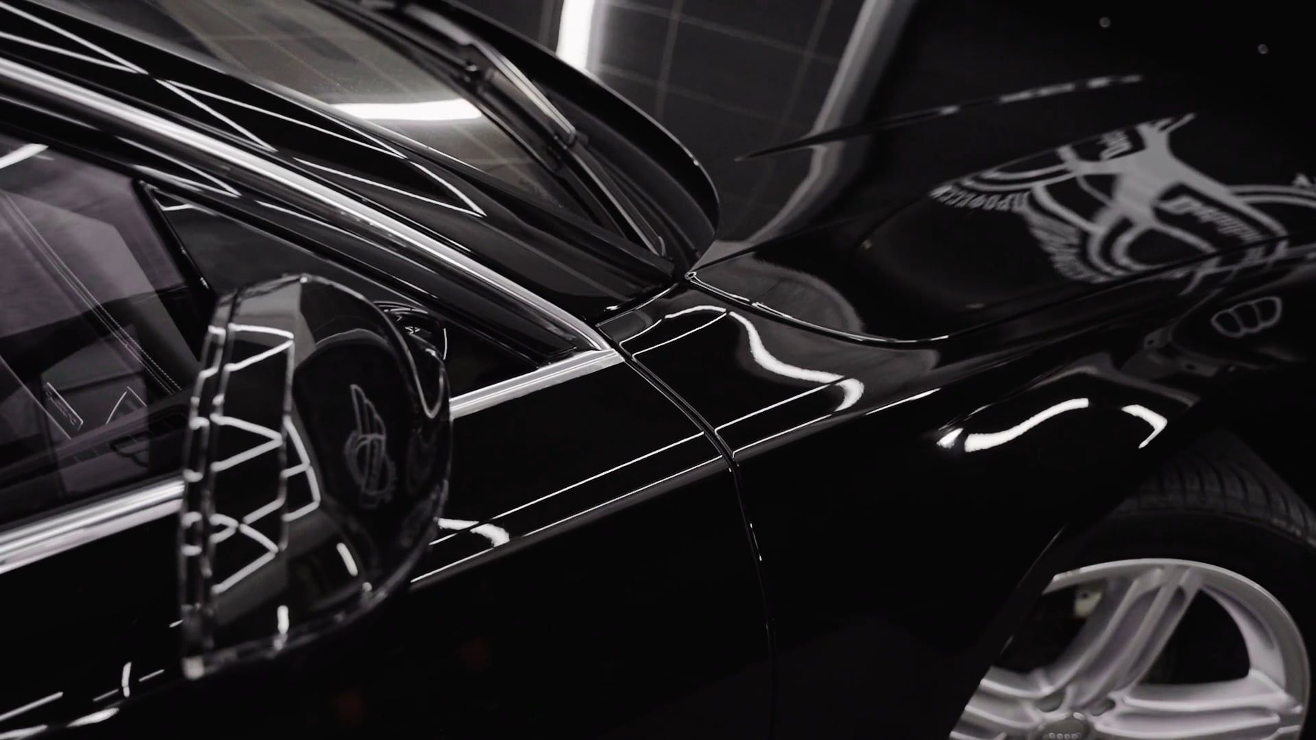 Detailer carefully finishing a black luxury sedan